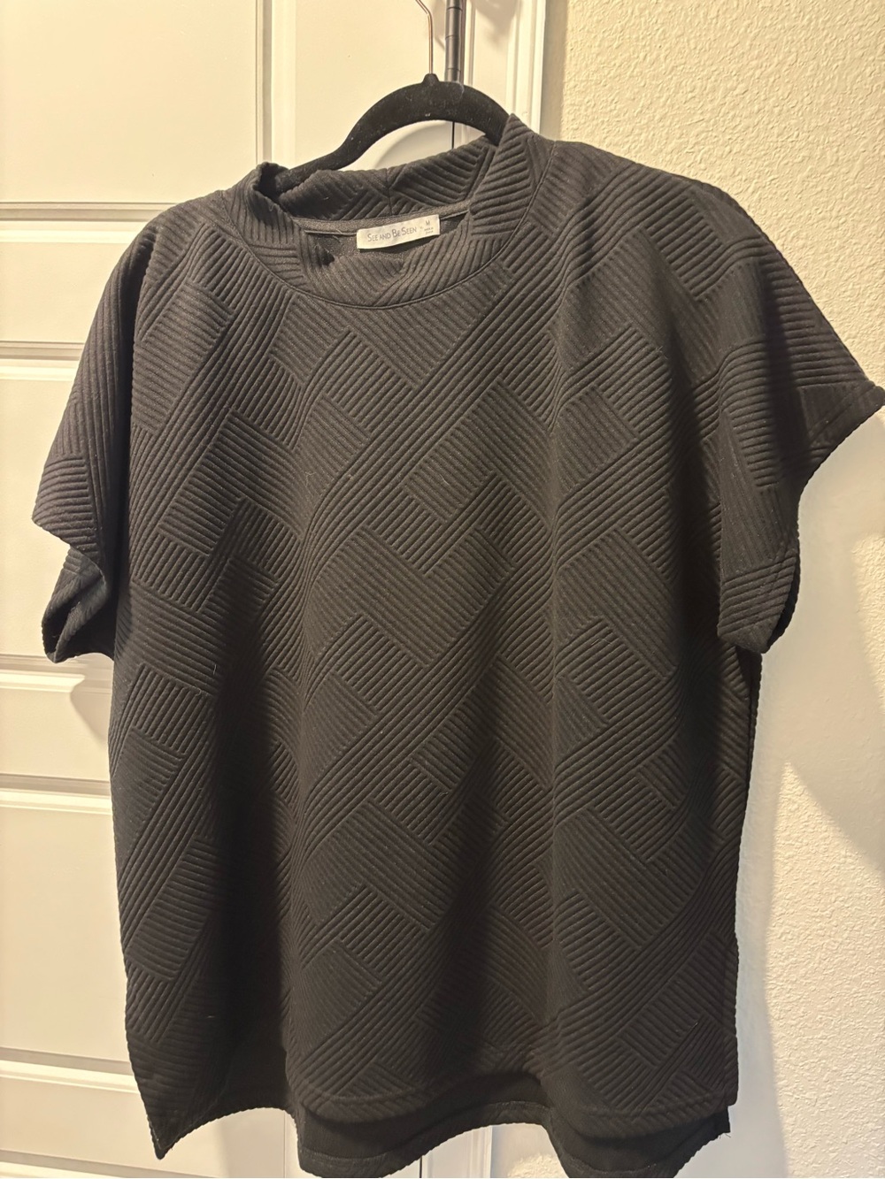 See and Be Seen Black oversized Geometric Short Sleeve top with side slits.